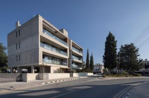 a building on the side of a street at Malberry Park 103 - Modern Apt with Shared Heated Pool, Sauna, Gym, Jacuzzi in Paphos City