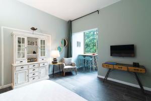 une chambre avec un lit, une télévision et un bureau dans l'établissement Raphael City Nest, à Tel Aviv