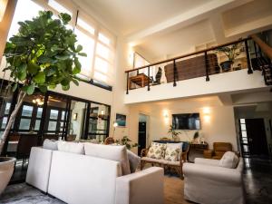 a living room with white couches and a plant at Rare, Special Beach Pool Villa in Hua Hin