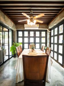 a dining room with a ceiling fan and a table with chairs at Rare, Special Beach Pool Villa in Hua Hin