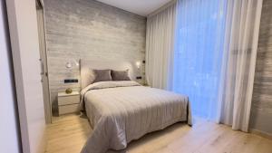 una camera da letto con un letto e una grande finestra di Malberry Park 104 - Modern Apt with Shared Heated Pool, Sauna, Gym, Jacuzzi a Paphos Altre 16 foto