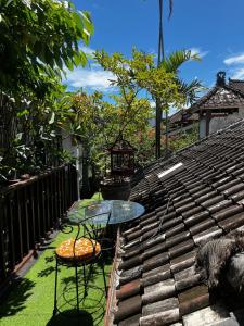 a glass table and chairs sitting on top of a roof at 1 BR Cozy Apartment in center of Seminyak in Seminyak