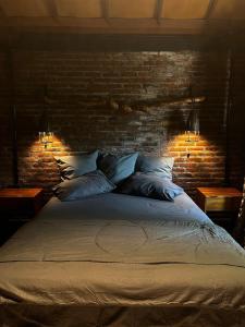 a bedroom with a bed with a brick wall at 1 BR Cozy Apartment in center of Seminyak in Seminyak