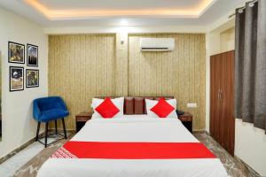 Una habitación de hotel con una cama y una silla azul. en Hotel O Uday, en Jaipur