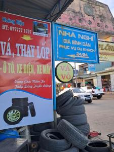 a bunch of tires are stacked next to a sign at Nhà Nghỉ Hoàng kim in Kon Plong
