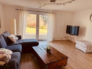 a living room with a couch and a table and a tv at Ferienwohnung im Grünen in Witten