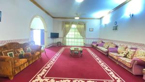 a living room with couches and a red carpet at Private Cottage in Sharjah