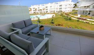 a balcony with a couch and a table and a building at Ocean Home - Costa Ballena in Costa Ballena +28 photos
