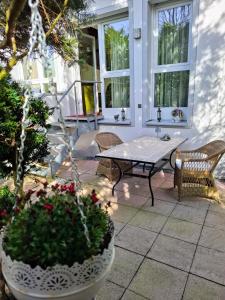 a patio with a table and chairs and flowers at Auszeit im Jugendstil in Schopfloch +20 photos