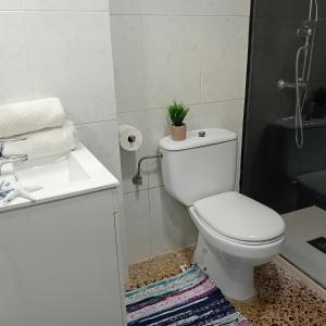 a white bathroom with a toilet and a sink at María PLAYA BRISA NG in Peniscola