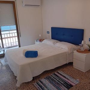a bedroom with a large bed with a blue headboard at María PLAYA BRISA NG in Peniscola