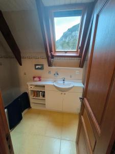Un baño con lavabo y ventana. en Très beau chalet familial, en La Colmiane