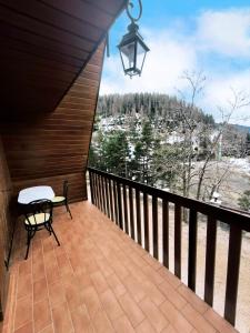 balcón con mesa y vistas a las montañas en Très beau chalet familial, en La Colmiane