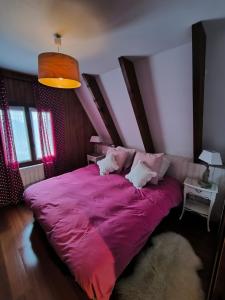 1 cama grande en un dormitorio con manta rosa en Très beau chalet familial, en La Colmiane