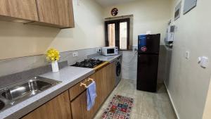 a small kitchen with a sink and a refrigerator at HomeStay in Ikuata