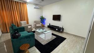 a living room with a green couch and a tv at HomeStay in Ikuata
