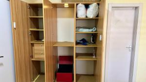 a closet with wooden shelves and a door at HomeStay in Ikuata