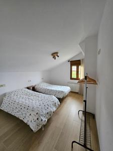 a bedroom with two beds and a window at El Tayo in Cudillero