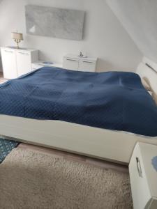 a bedroom with a bed with a blue comforter at Ferienwohnung Beck in Buttstädt