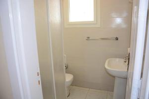 a bathroom with a white toilet and a sink at شالية فندقي في دلتا شرم ريزورت in Sharm El Sheikh