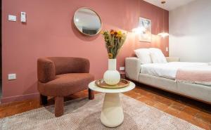 a bedroom with a bed and a chair and a mirror at La voyageuse in Tournus +3 photos