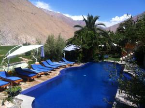 a swimming pool with lounge chairs and a mountain at Cabañas Caballieri in Pisco Elqui