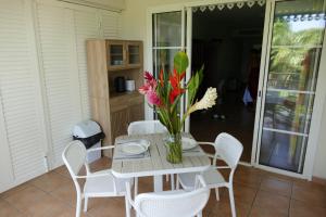 a table with a vase of flowers on it at PIERRE & VACANCES Tobago 24 in Sainte-Luce