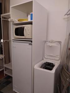 a small refrigerator with a microwave and a washer at Studio l'Olivette T1 in Avignon