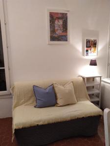 a couch with two pillows on it in a room at Studio l'Olivette T1 in Avignon