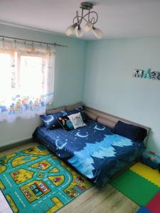 a bedroom with a blue bed and a rug at Morrison Village in Miercurea-Ciuc