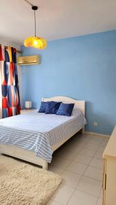 a bedroom with a bed with a blue wall at 2 bedroom Apartment Seaview Flic en Flac in Flic-en-Flac