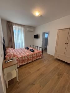 a bedroom with a bed and a table in it at MARIS Apartments & Bedrooms in Alghero