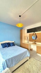 a bedroom with a bed and a blue wall at 2 bedroom Apartment Seaview Flic en Flac in Flic-en-Flac