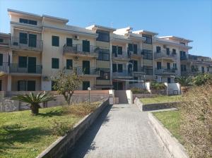 a walkway in front of a large apartment building at Sileno Beach Giardini Naxos in Giardini Naxos