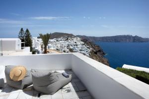 a balcony with chairs and a view of the ocean at ArmonOia Suites Santorini in Oia