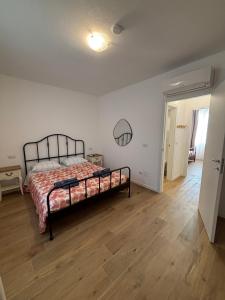a bedroom with a bed and a wooden floor at MARIS Apartments & Bedrooms in Alghero