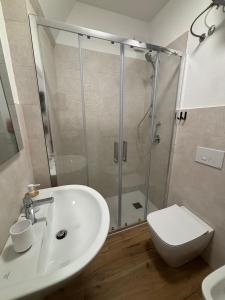 a bathroom with a shower and a sink and a toilet at MARIS Apartments & Bedrooms in Alghero