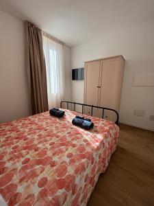 a bedroom with a bed with two black objects on it at MARIS Apartments & Bedrooms in Alghero