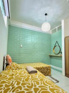 a bedroom with a bed and a green tiled wall at 2 bedroom Apartment Seaview Flic en Flac in Flic-en-Flac +7 photos