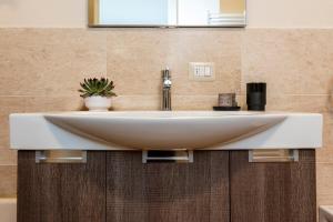 a sink in a bathroom with a potted plant at Suite Deluxe in Palazzo Storico - Centro Sassari - Appartamento Porto Vecchio in Sassari +29 photos