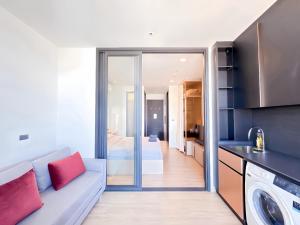 a kitchen and living room with a couch and a bed at Edge Central Pattaya Oasis in Pattaya Central