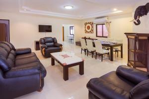 a living room with leather furniture and a dining room at Villa Marcello in Pattaya South