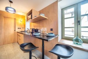 a kitchen with a counter and two stools in it at L'aventurière in Tournus