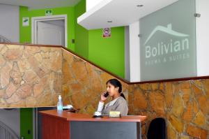 a woman sitting at a podium talking on a phone at Bolivian Rooms & Suites (Zona Sur) in La Paz