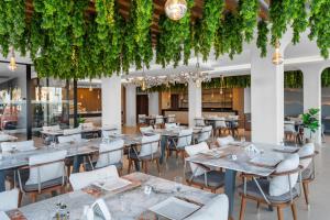 a restaurant with tables and chairs and vines at Beach Albatros The Club - Aqua Park in Hurghada +195 photos