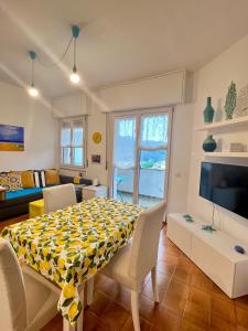 un soggiorno con tavolo, sedie e televisione di La casa Marina a Rapallo