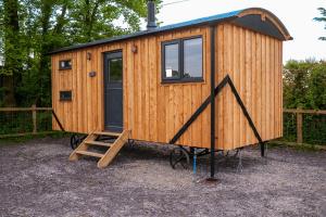 梅奈布里奇Cybi, Modern Shepherds Hut with Games Room Access的一座木制的小房子,有楼梯通往