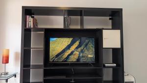 a tv in a black entertainment center at Playa del Cura - Mar Paraiso in Playa del Cura