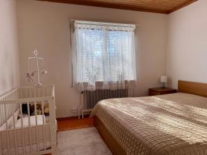 a bedroom with a bed and a window and a crib at KalmarStay in Blomstermåla