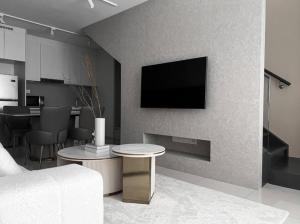 a living room with a tv on a wall at Loft Suite Eko Cheras in Kuala Lumpur +3 photos